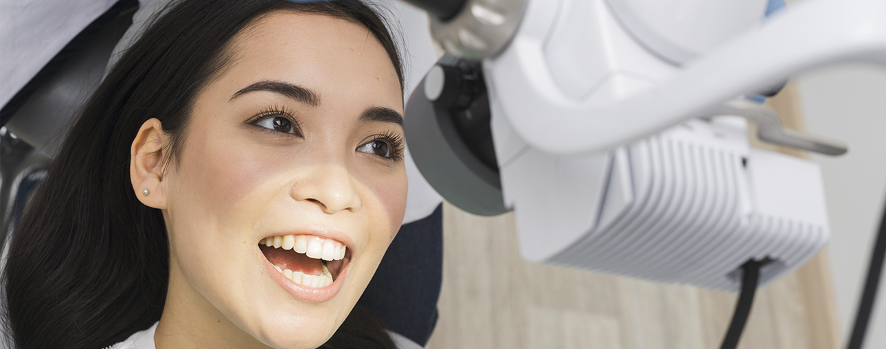 Young woman smiling in dental chair during examination at family dental office.