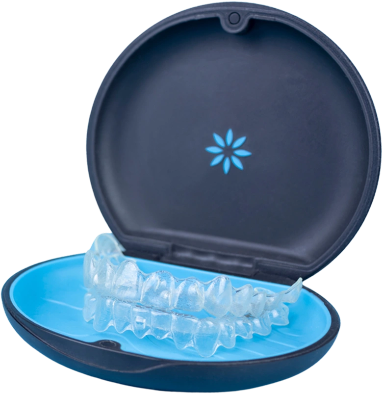 Clear dental aligners in open blue case with snowflake logo, dental treatment storage.