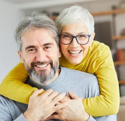 Happy mature couple smiling together at Oceanside dental practice.